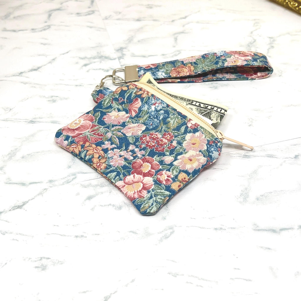 Floral patterned pouch with matching wristlet key chain. on a white marble background