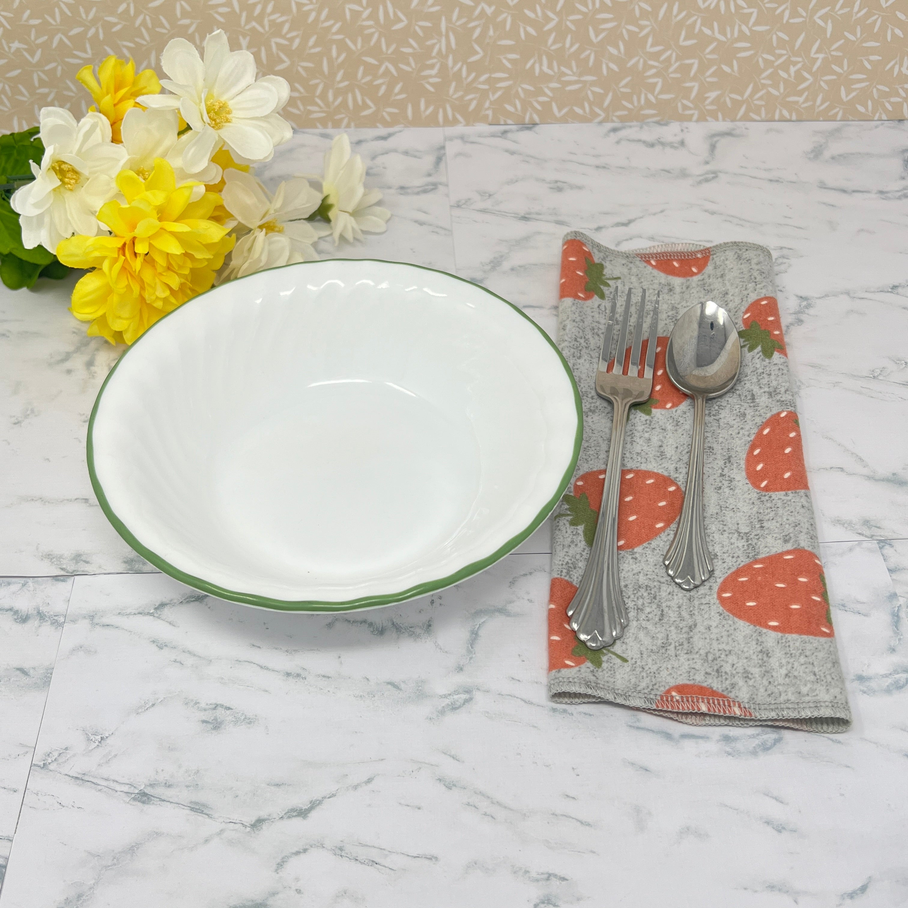 Flannel reusable paper towels. This pictures shows the towel being used as a paper napkin alternative with place setting on table. Cotton fabric has random red strawberries on a heather gray background