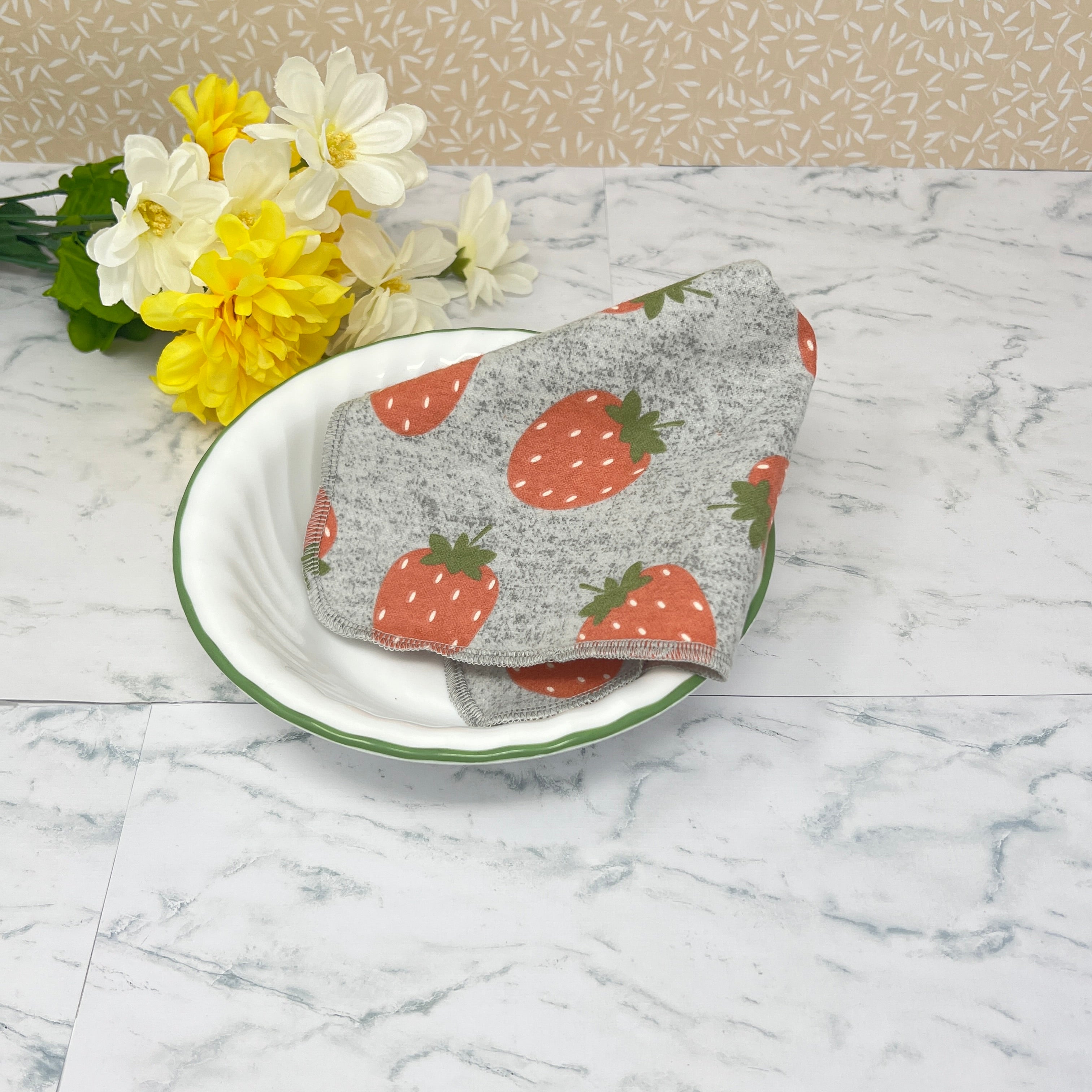 Flannel reusable paper towels. This pictures shows a single towel as a paper napkin alternative.  Cotton fabric has random red strawberries on a heather gray background