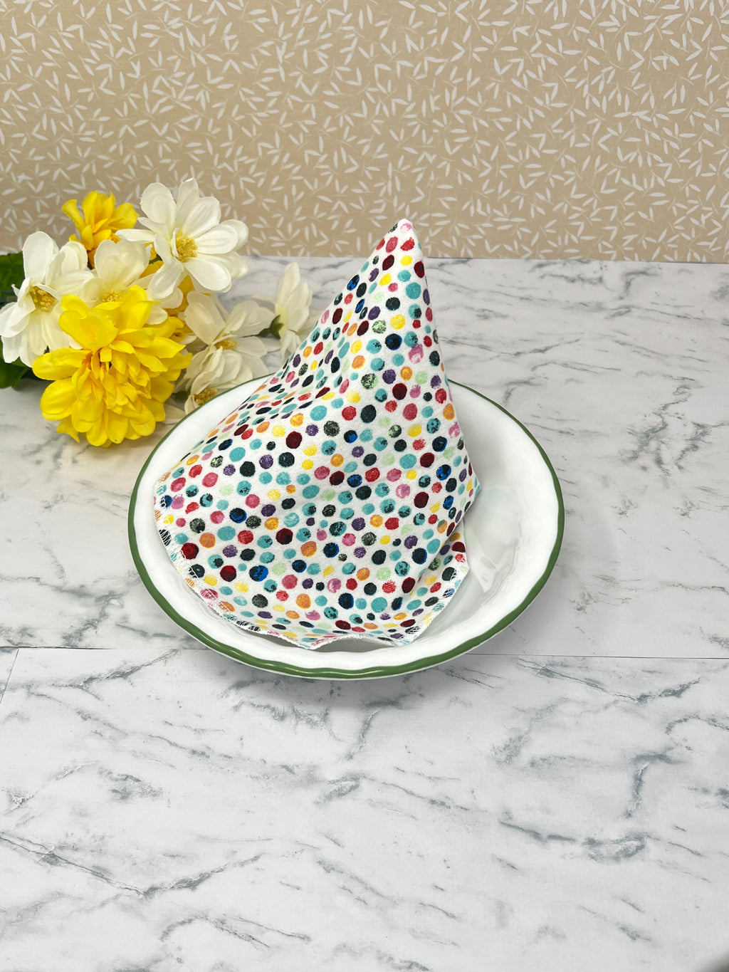 Flannel reusable paper towels. This pictures shows possible use as a napkin in a place setting.  Cotton flannel fabric has a colorful confetti dot pattern on a white background