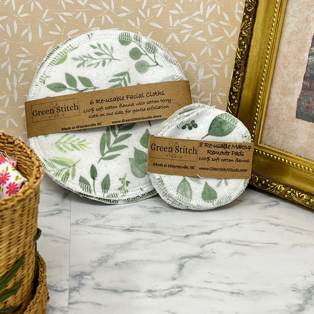 Reusable facial cloths with green leaf pattern on a marble surface, branded 'Green Stitch'.