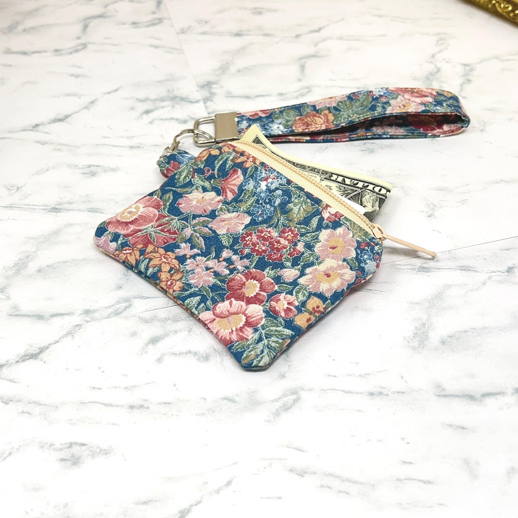 Floral patterned zippered  pouch with a matching keychain wristlet on a marble surface