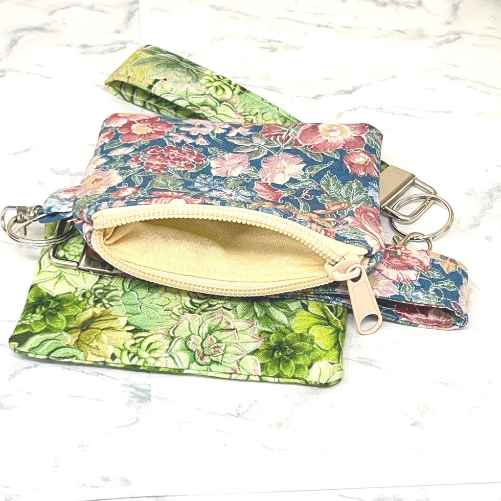 Floral patterned pouch with a zipper and showing the cream colored lining. matching Wristlet